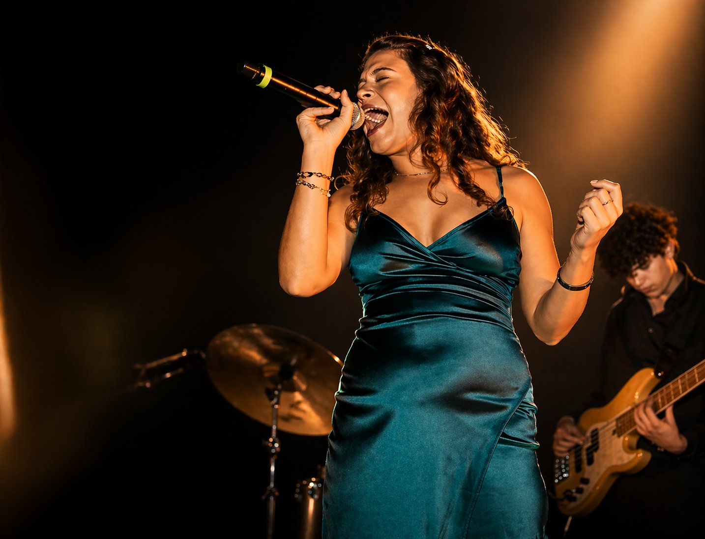 Wresh Workshop student Gabi performing on stage in a green dress